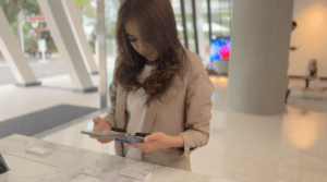 S3100V와 휴대폰을 비교하는 여성